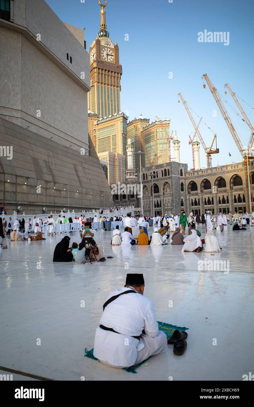 La Mecque, Arabie Saoudite - 1er juin 2024 : pèlerins du Hadj et de l'Umrah assis près de Masjidil Haram, Grande Mosquée de la Mecque avec la Tour de l'horloge. Hajj 2 Banque D'Images