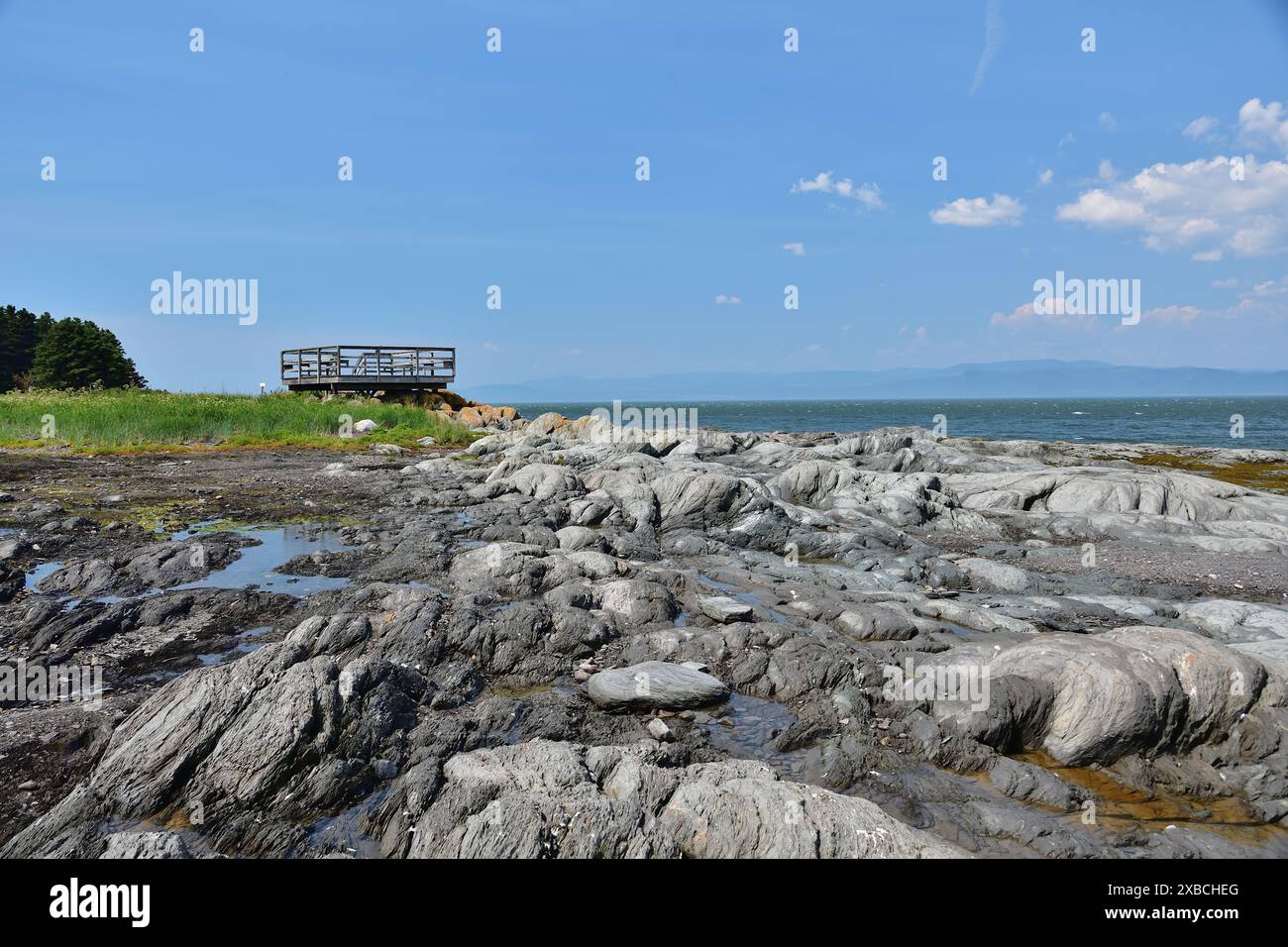 Plate-forme observatoire en bois sur Island cape par une journée ensoleillée. Rochers arrondis par l'océan. Ile aux lièvres sur le fleuve Saint-Laurent Banque D'Images