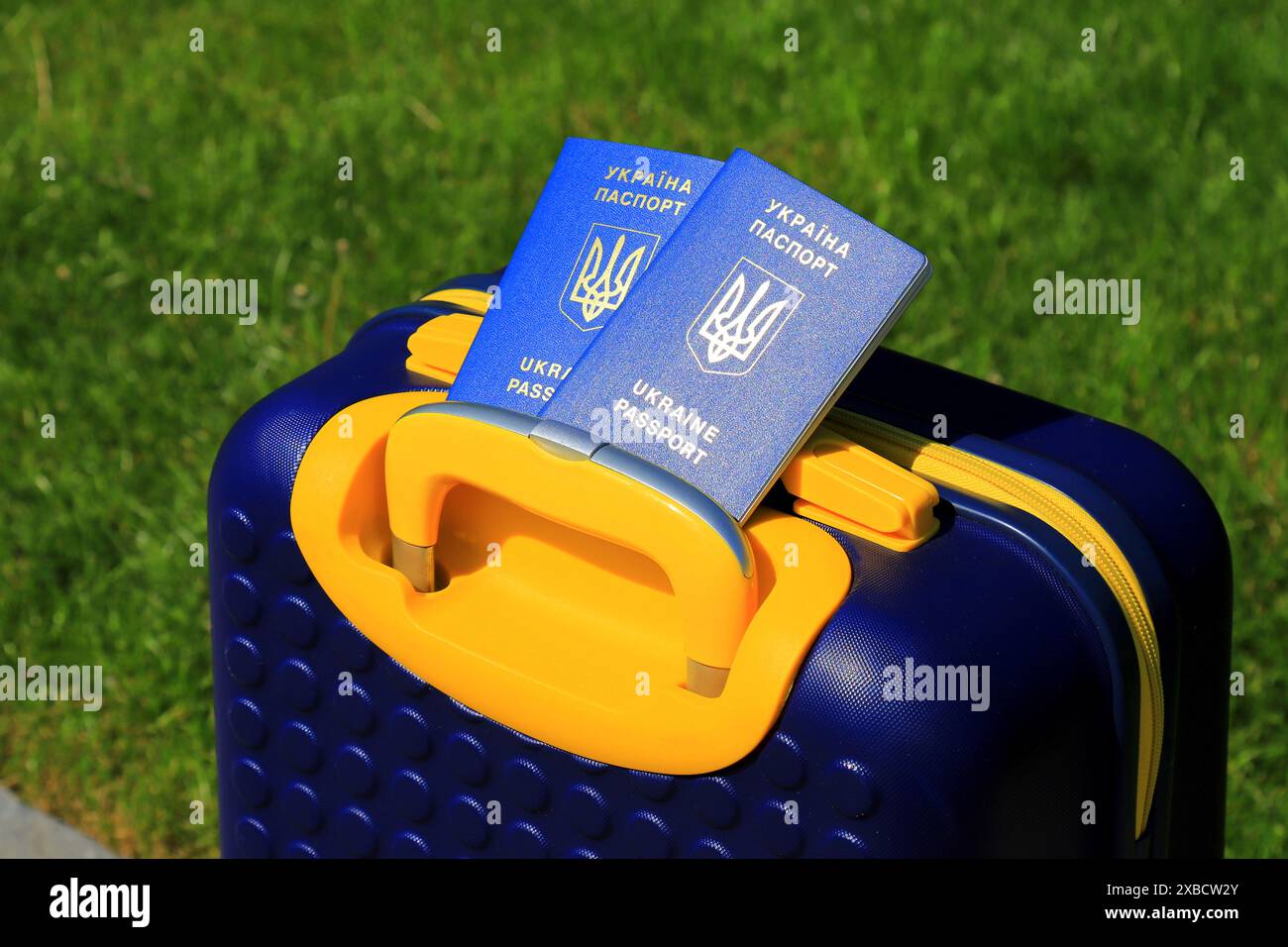 2 passeports Ukraine citoyens avec inscription en ukrainien - passeport de l'Ukraine reposent sur la valise jaune bleu en couleur du drapeau ukrainien. Voyage, refuge Banque D'Images