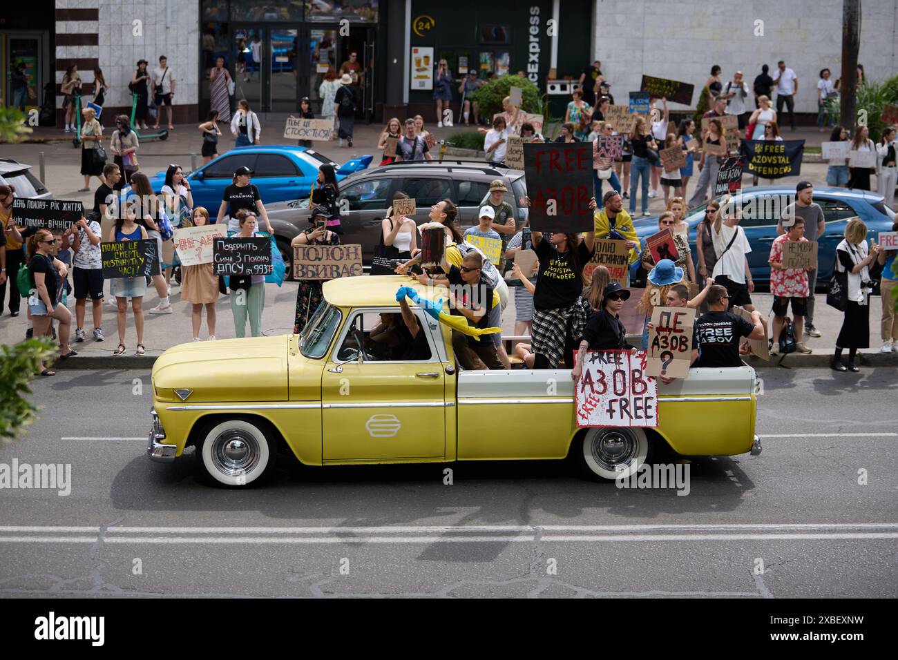 Des militants ukrainiens montent dans une camionnette rétro américaine GMC 1964 lors d'une manifestation publique. Kiev - 9 juin 2024 Banque D'Images