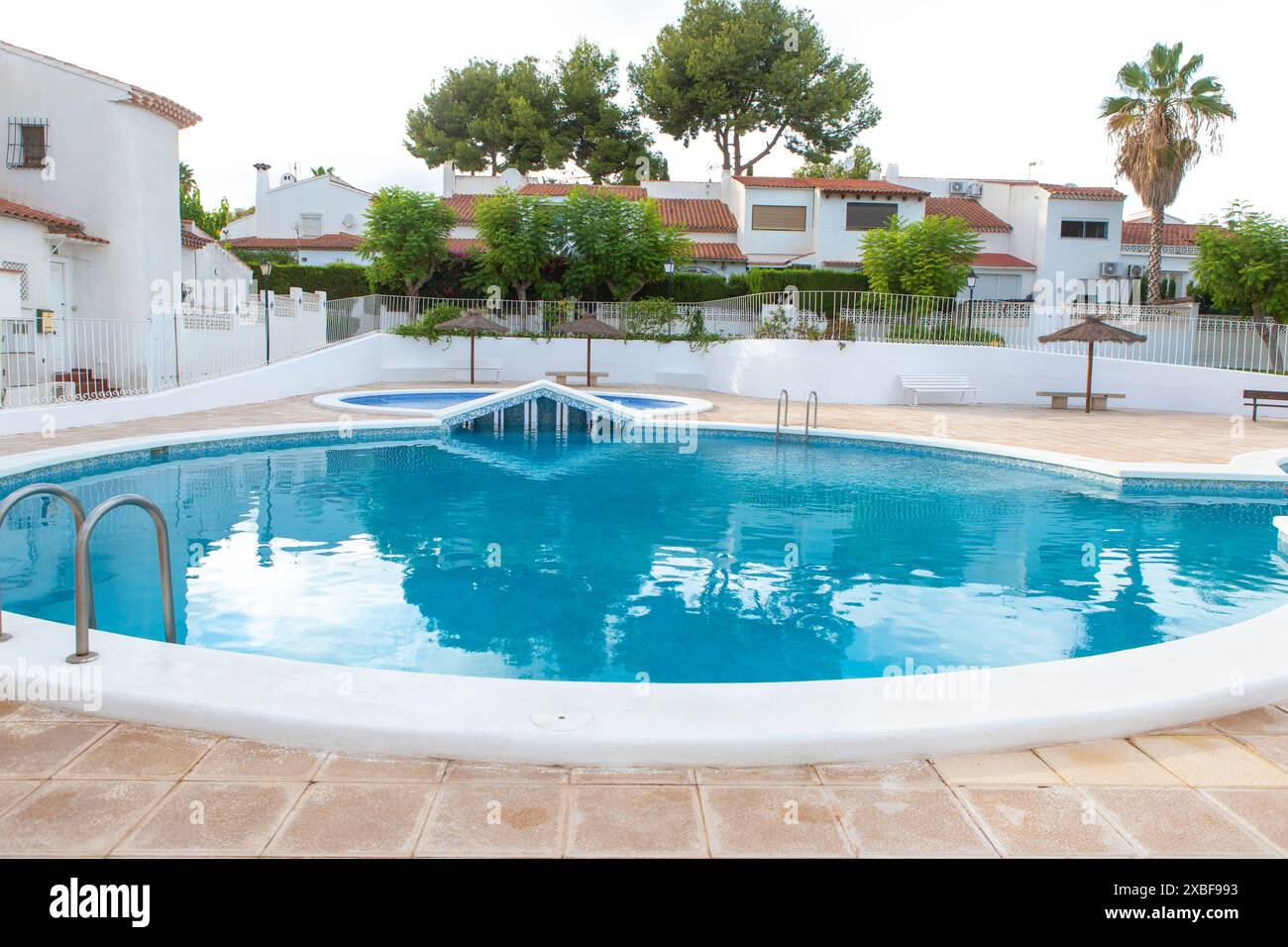 Piscine résidentielle dans un complexe de logements moderne avec une eau bleue claire et la verdure environnante Banque D'Images