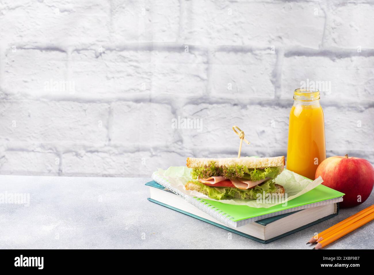 Snack pour l'école avec sandwich, pomme fraîche et jus d'orange. Fournitures scolaires colorées Copier l'espace, Banque D'Images Snack pour l'école avec sandwich, pomme fraîche et jus d'orange. Fournitures scolaires colorées Copier l'espace, Banque D'Images
