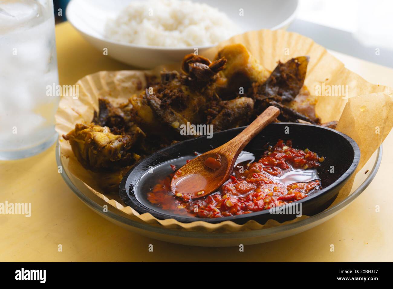 Sambal, sauce piment traditionnelle indonésienne, servi avec du poulet frit traditionnel accompagné de curcuma et de riz chaud à la vapeur Banque D'Images