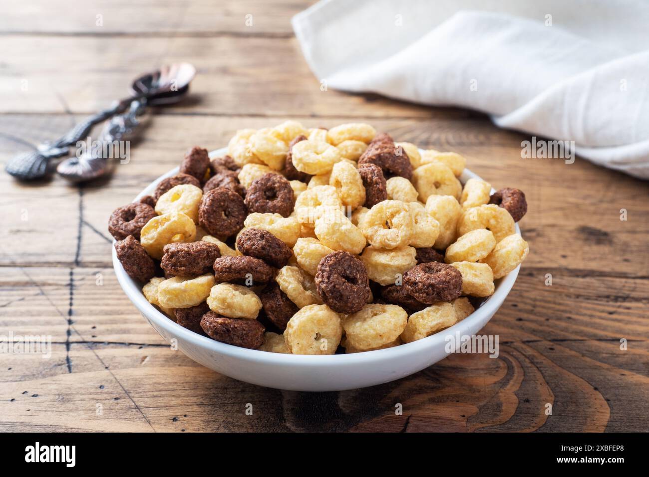 Céréales sèches pour le petit-déjeuner. Anneaux de chocolat et de maïs fabriqués à partir de céréales naturelles avec du lait dans une assiette. Fond rustique en bois, espace de copie Banque D'Images Céréales sèches pour le petit-déjeuner. Anneaux de chocolat et de maïs fabriqués à partir de céréales naturelles avec du lait dans une assiette. Fond rustique en bois, espace de copie Banque D'Images