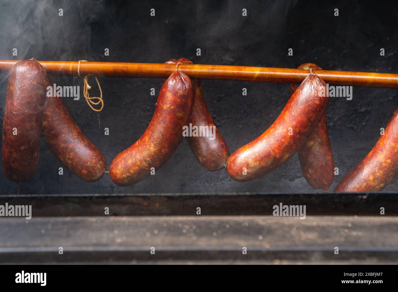 Saucisses suspendues sur le rack dans un fumeur décalé avec une fumée épaisse, fermé Banque D'Images