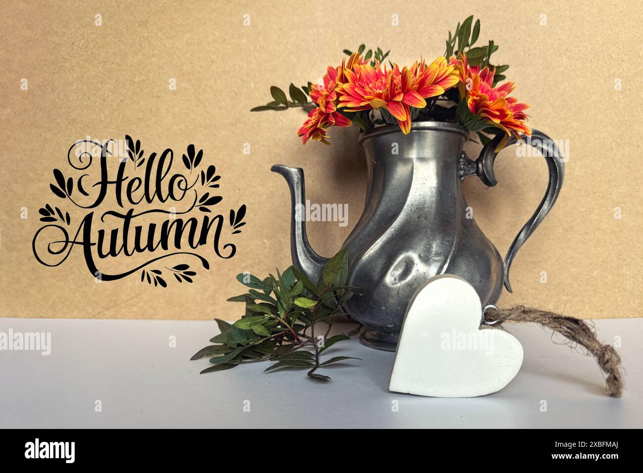 Fleurs d'automne en théière Vintage avec décoration de coeur et signe Hello Autumn Banque D'Images