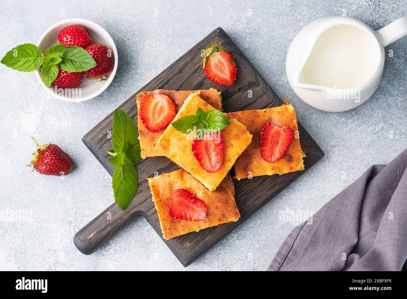 Casserole de fromage cottage avec fraises et menthe. Délicieux dessert fait maison à base de lait caillé et de baies fraîches avec fond de béton gris crème CLO Banque D'Images Casserole de fromage cottage avec fraises et menthe. Délicieux dessert fait maison à base de lait caillé et de baies fraîches avec fond de béton gris crème CLO Banque D'Images