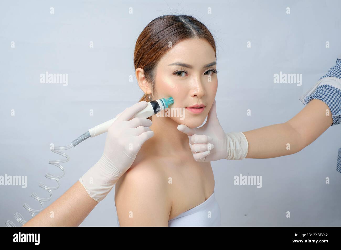 Magnifique femme asiatique subissant SilkPeel facial pour le soulagement de l'acné et de la rosacée Banque D'Images