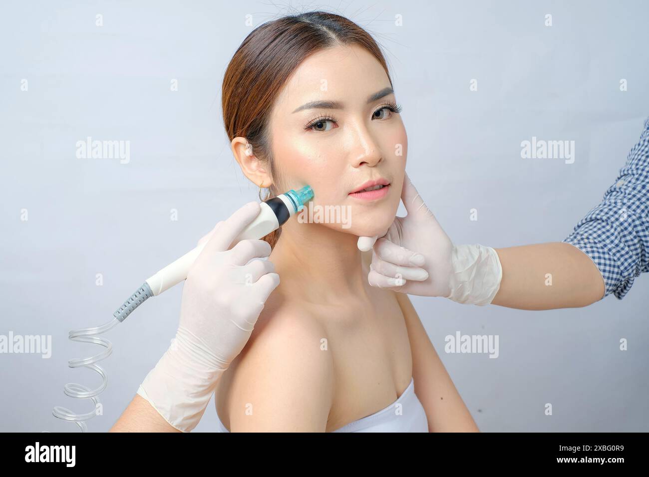 Femme asiatique élégante subissant SilkPeel facial pour une peau claire et lisse Banque D'Images