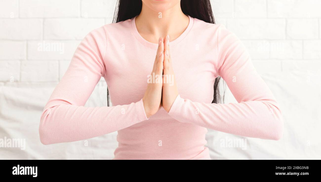 Femme en chemise rose faisant du yoga, Cropped Banque D'Images