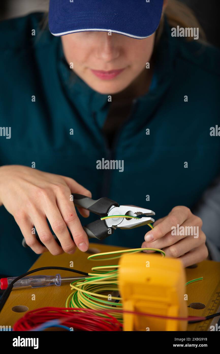 jeune femme ingénieur de maintenance testant la tension avec un multimètre numérique Banque D'Images