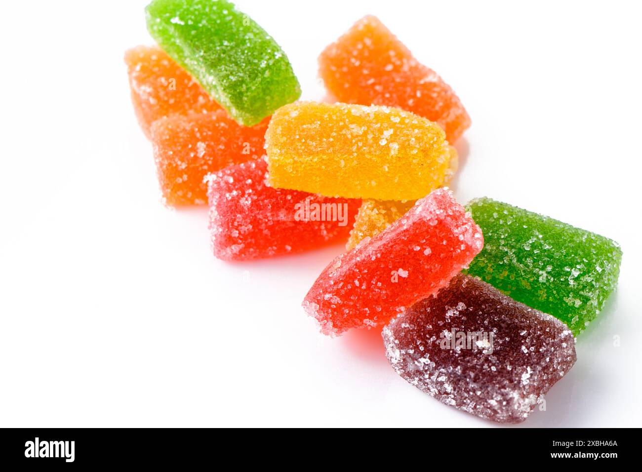 Sucré délicieux marmelade multicolore ou bonbons à la gelée assortis dans des saupoudrées de sucre avec une saveur de fruits et de baies sur un fond blanc. 1 Banque D'Images