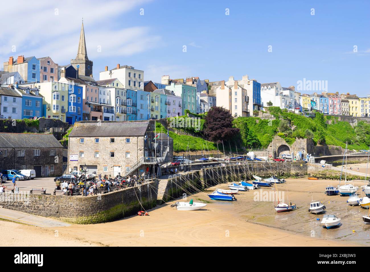 Tenby maisons colorées au-dessus de la plage du port de Tenby avec de petits bateaux amarrés à marée basse Tenby Port de Tenby Carmarthan Bay Pembrokeshire West Wales UK GB Banque D'Images