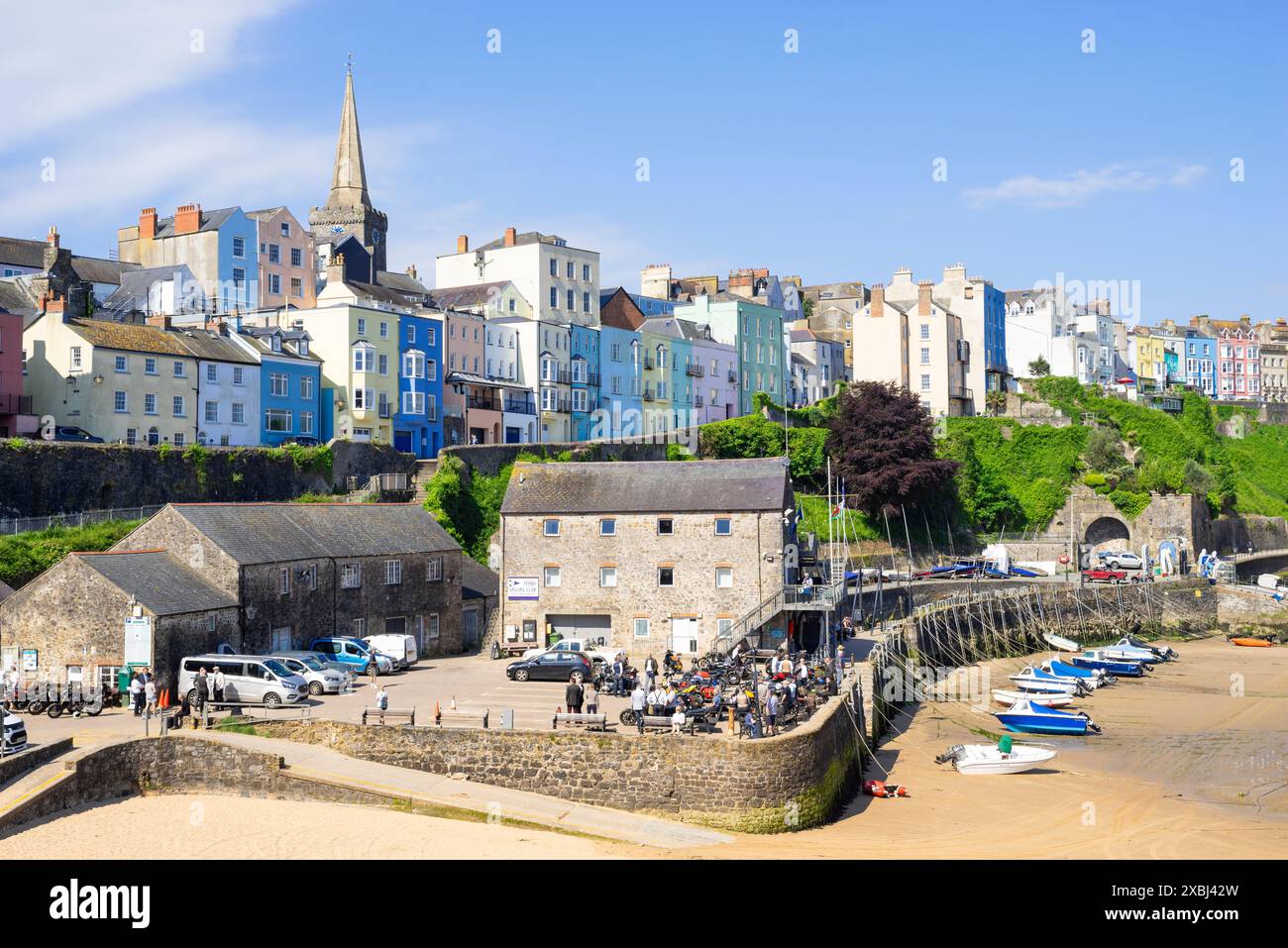 Tenby maisons colorées au-dessus de la plage du port de Tenby avec de petits bateaux amarrés à marée basse Tenby Port de Tenby Carmarthan Bay Pembrokeshire West Wales UK GB Banque D'Images