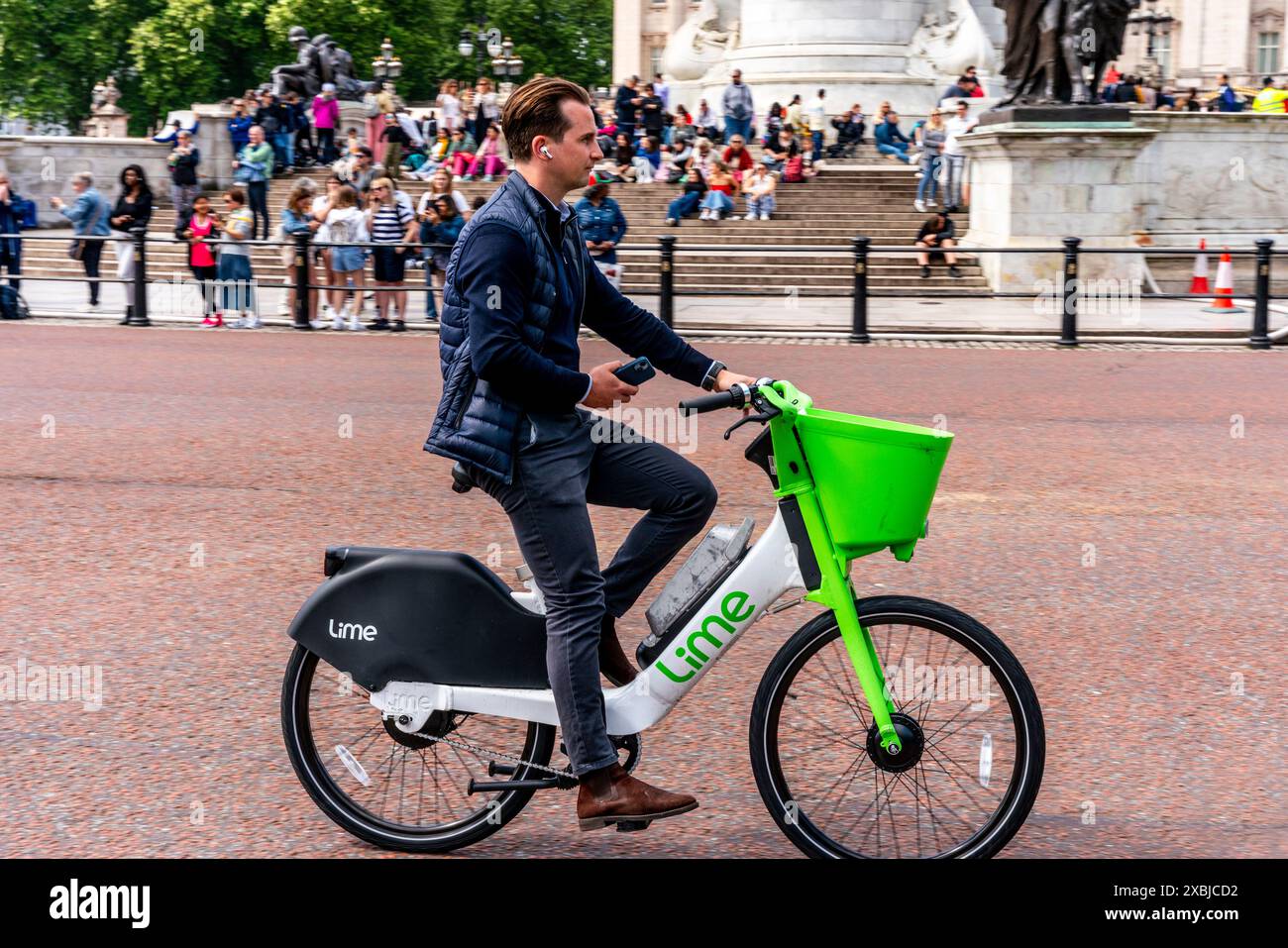 Un homme conduisant Un vélo électrique Lime dans le centre de Londres, Londres, Royaume-Uni. Banque D'Images