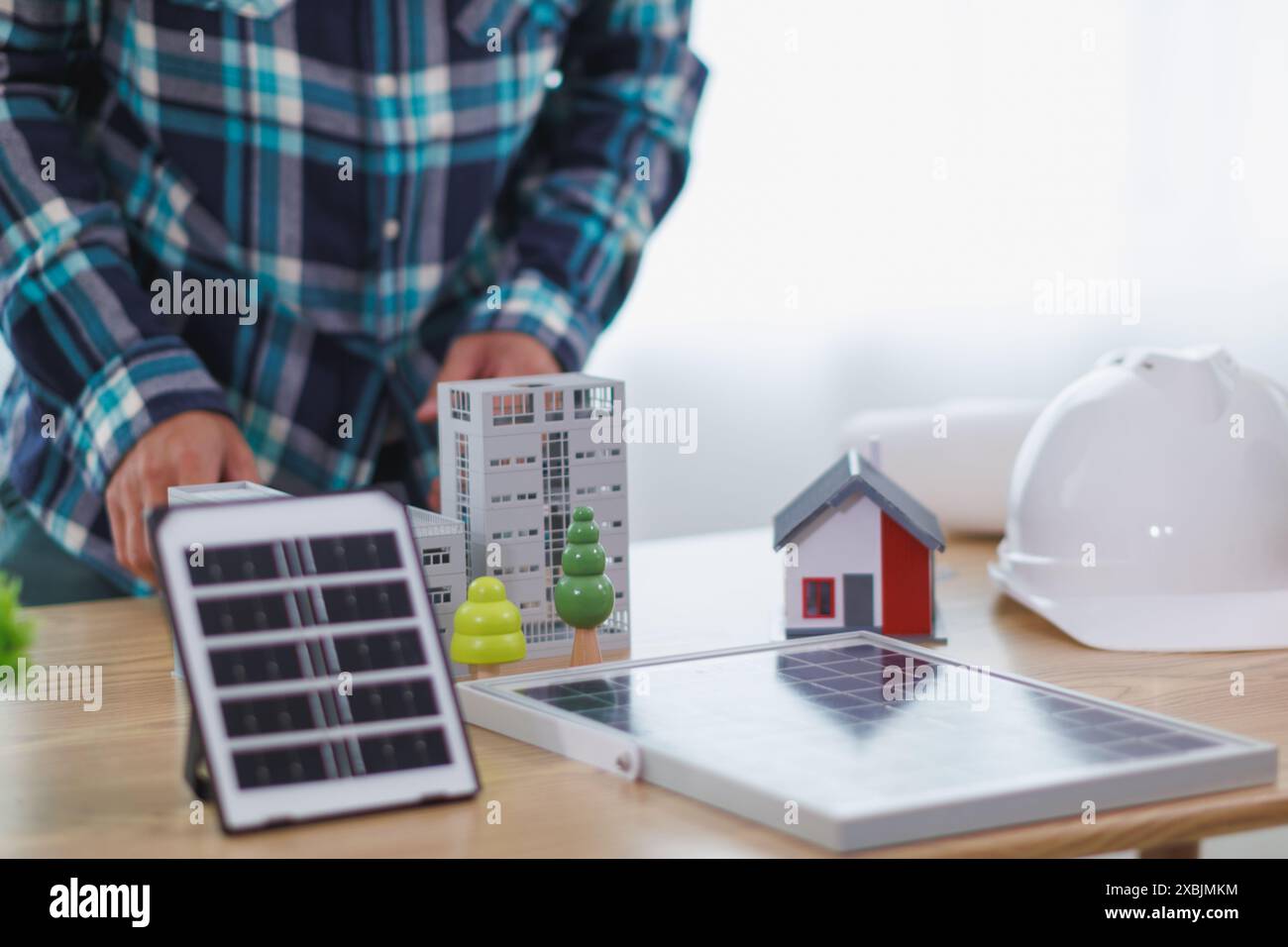 Les ingénieurs examinent les plans des architectes pour préparer l’installation de panneaux solaires et d’éoliennes sur le bâtiment afin de produire efficacement de l’électricité Banque D'Images