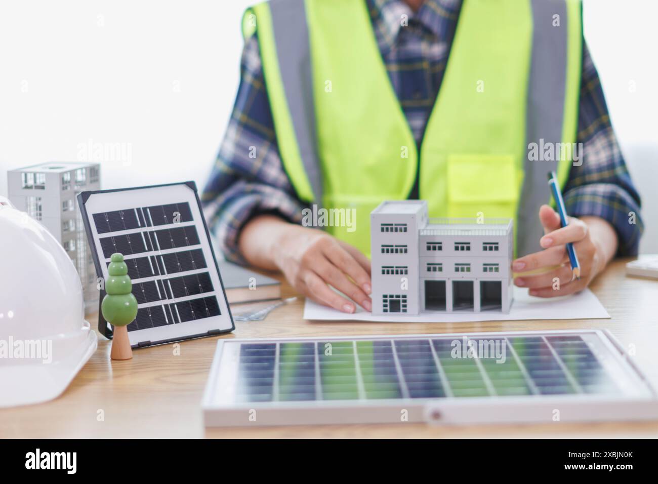 Les ingénieurs examinent les plans des architectes pour préparer l’installation de panneaux solaires et d’éoliennes sur le bâtiment afin de produire efficacement de l’électricité Banque D'Images