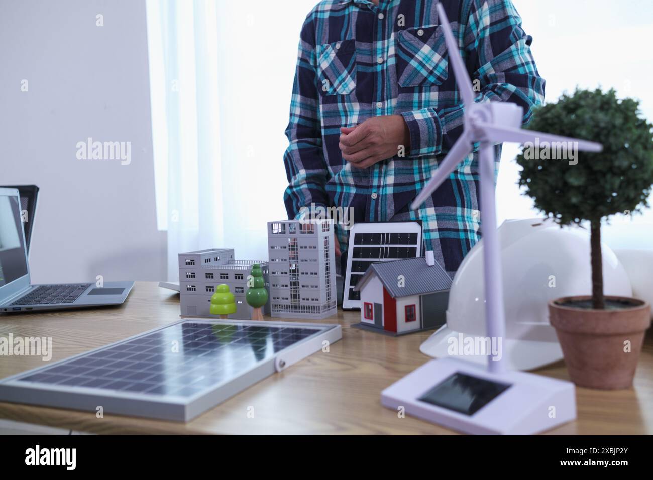 Les ingénieurs examinent les plans des architectes pour préparer l’installation de panneaux solaires et d’éoliennes sur le bâtiment afin de produire efficacement de l’électricité Banque D'Images