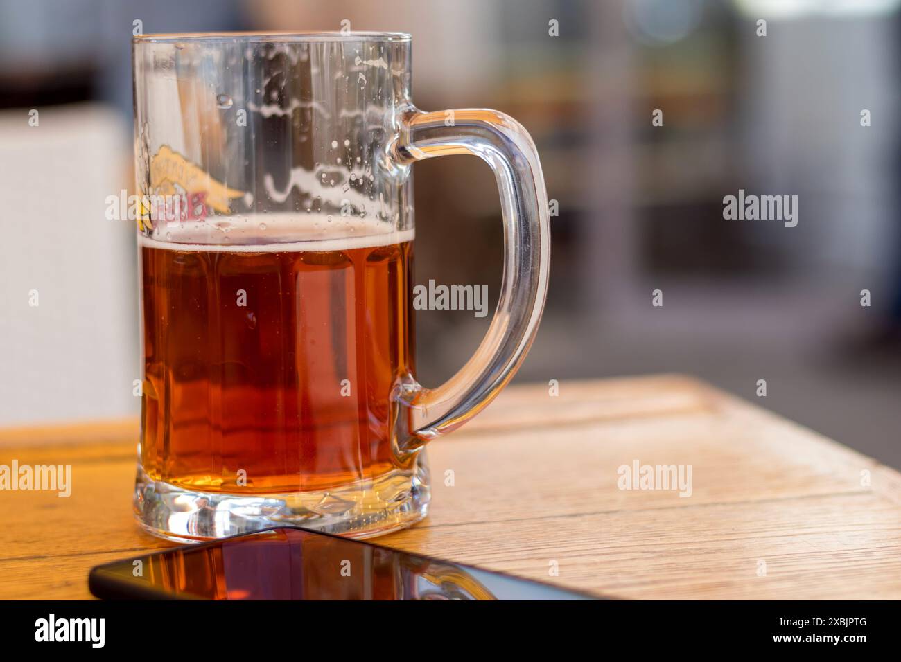 Tasse en verre avec de la bière sur une table en bois Banque D'Images