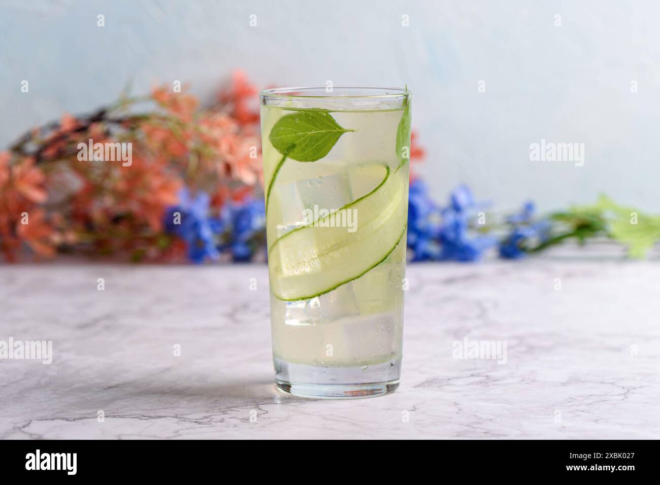 Fines tranches de concombre et feuilles de basilic dans une limonade sans alcool. Banque D'Images