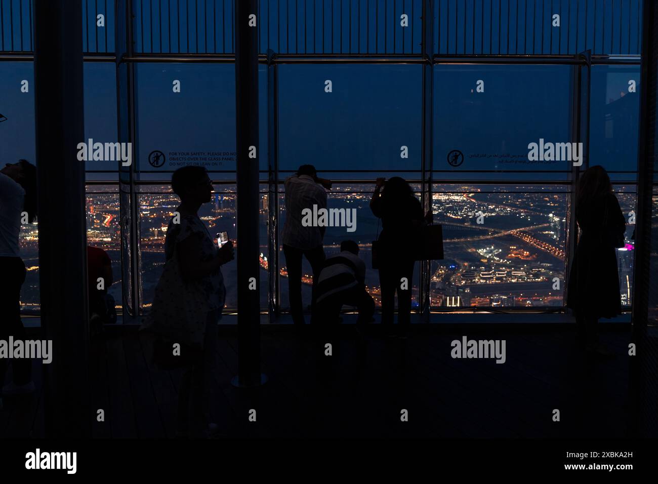 Dubaï, Émirats arabes Unis - 14 mars 2023 : les gens photographient le coucher de soleil et la vue depuis les fenêtres des étages supérieurs du Burj Khalifa pendant Banque D'Images