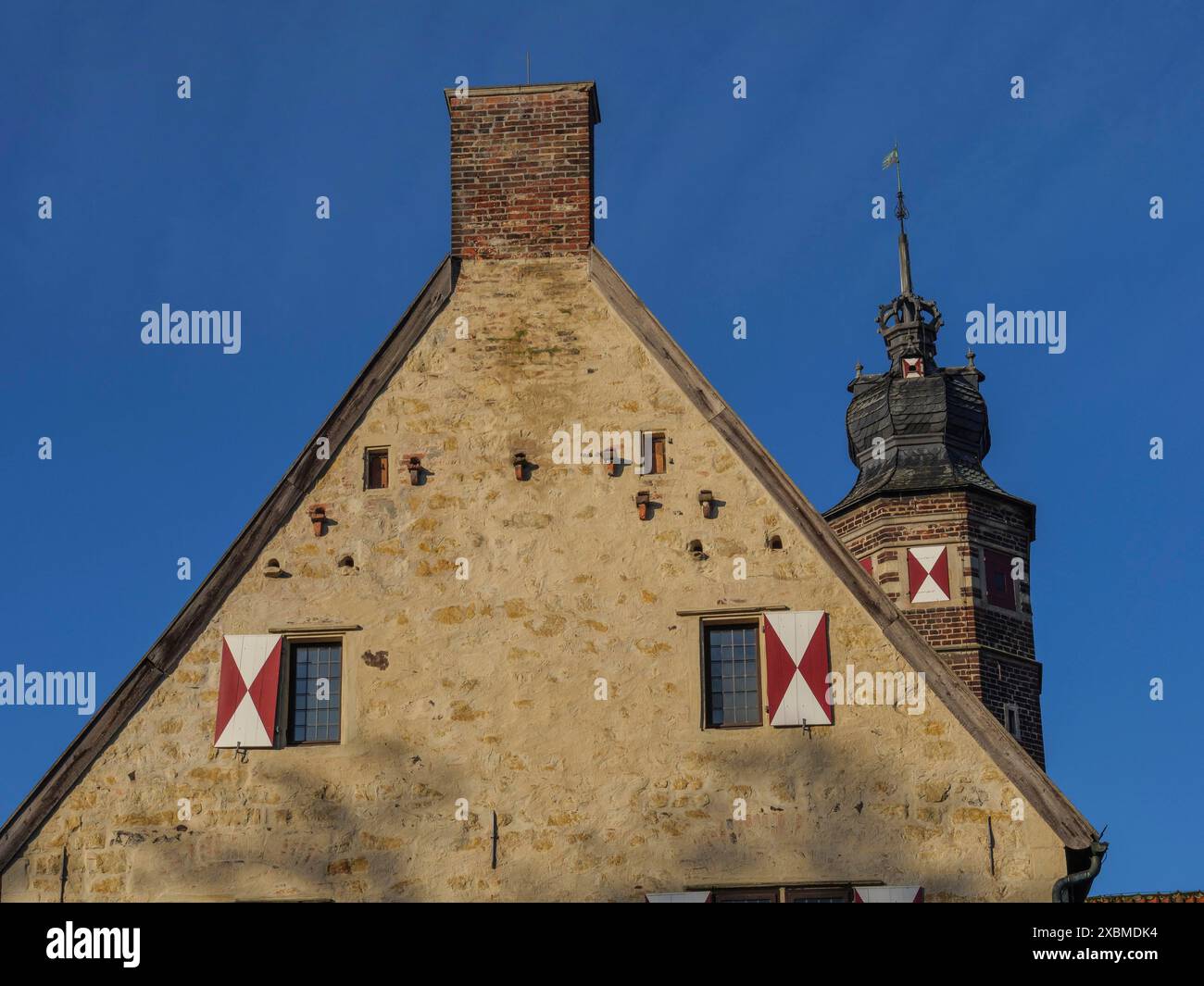 Bâtiment historique avec tour crénelée et toit de tuiles rouges, sous un ciel bleu clair, luedinghausen, westphalie, allemagne Banque D'Images