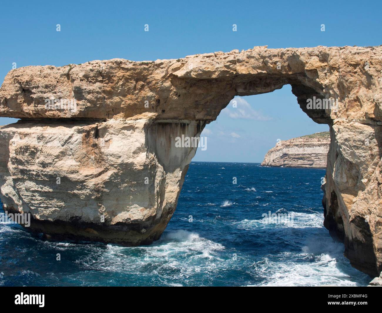 Une arche rocheuse naturelle au-dessus de la mer bleue avec des falaises abruptes en arrière-plan, gozo, mer méditerranée, malte Banque D'Images