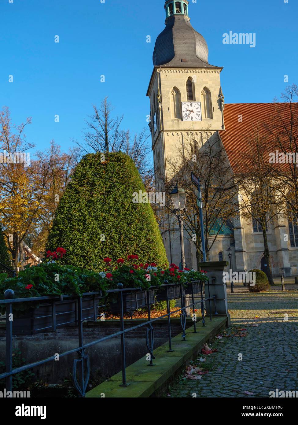 Église historique avec horloge sur la tour, entourée d'un jardin d'automne et de fleurs, nottuln, muensterland, allemagne Banque D'Images