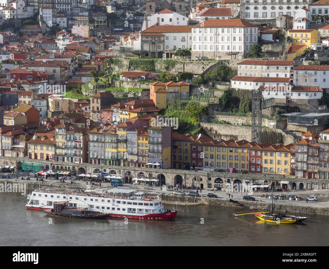 Vue sur une ville riveraine avec des maisons colorées et un bateau au premier plan, Porto, Douro, Portugal Banque D'Images