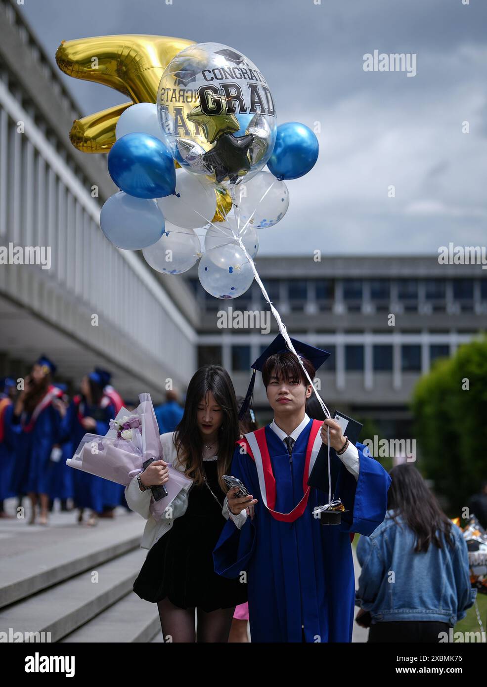 Burnaby, Canada. 12 juin 2024. Un étudiant diplômé de la Beedie School of Business tient des ballons avant une cérémonie de convocation à l'Université Simon Fraser, à Burnaby, en Colombie-Britannique, le mercredi 12 juin, 2024. crédit : The Canadian Press/Alamy Live News Banque D'Images