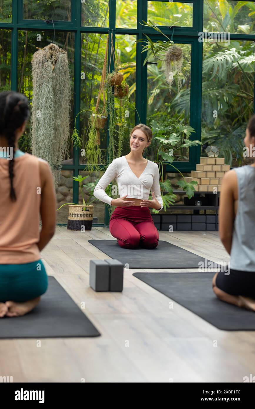 Un groupe diversifié de femmes pratiquant le yoga avec instructeur biracial, espace de copie Banque D'Images