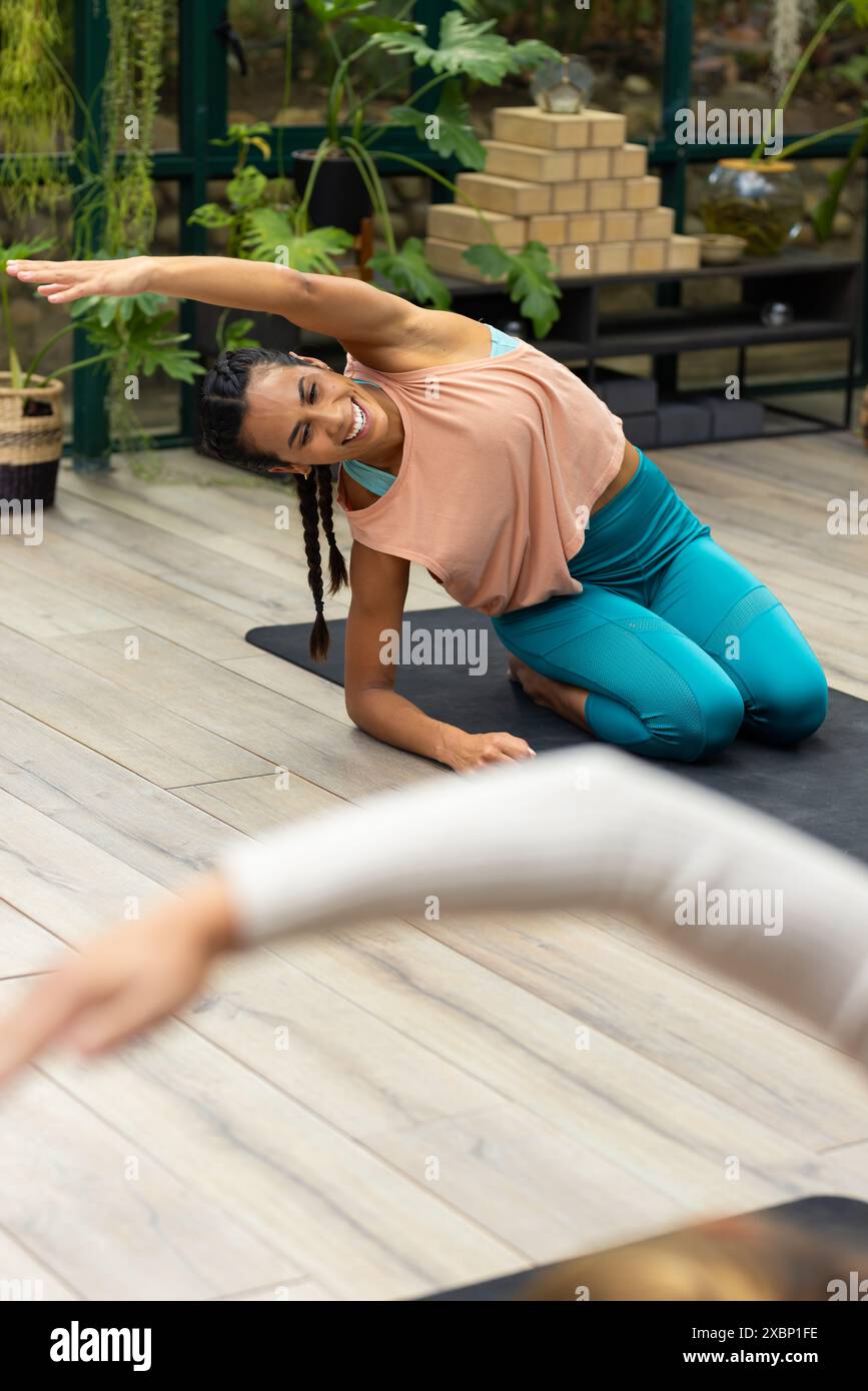 Instructeur de yoga biracial guidant un étudiant de yoga caucasien dans une pose Banque D'Images