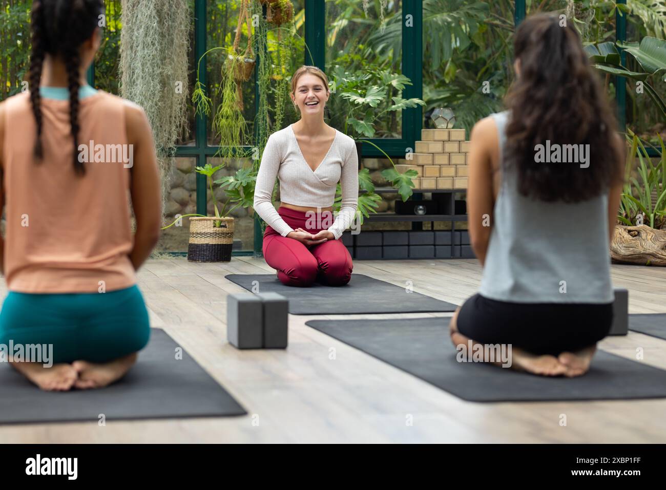 Un groupe diversifié de femmes pratiquant le yoga avec instructeur biracial Banque D'Images