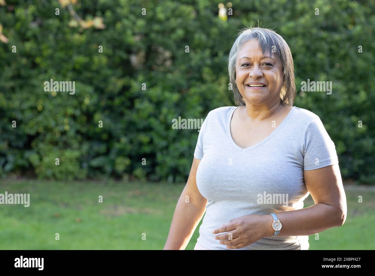 Femme senior biraciale souriant à l'extérieur dans une tenue décontractée, espace de copie Banque D'Images