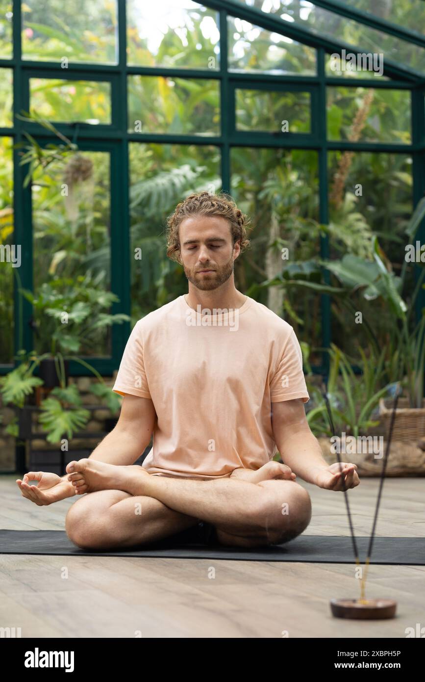 Praticien de yoga masculin caucasien méditant en position croisée Banque D'Images