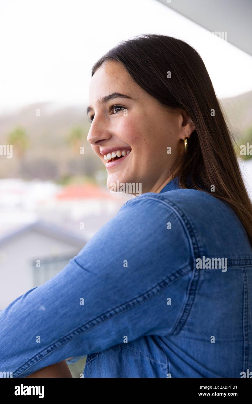 Jeune femme caucasienne souriante tout en profitant d'un moment de détente à la maison Banque D'Images