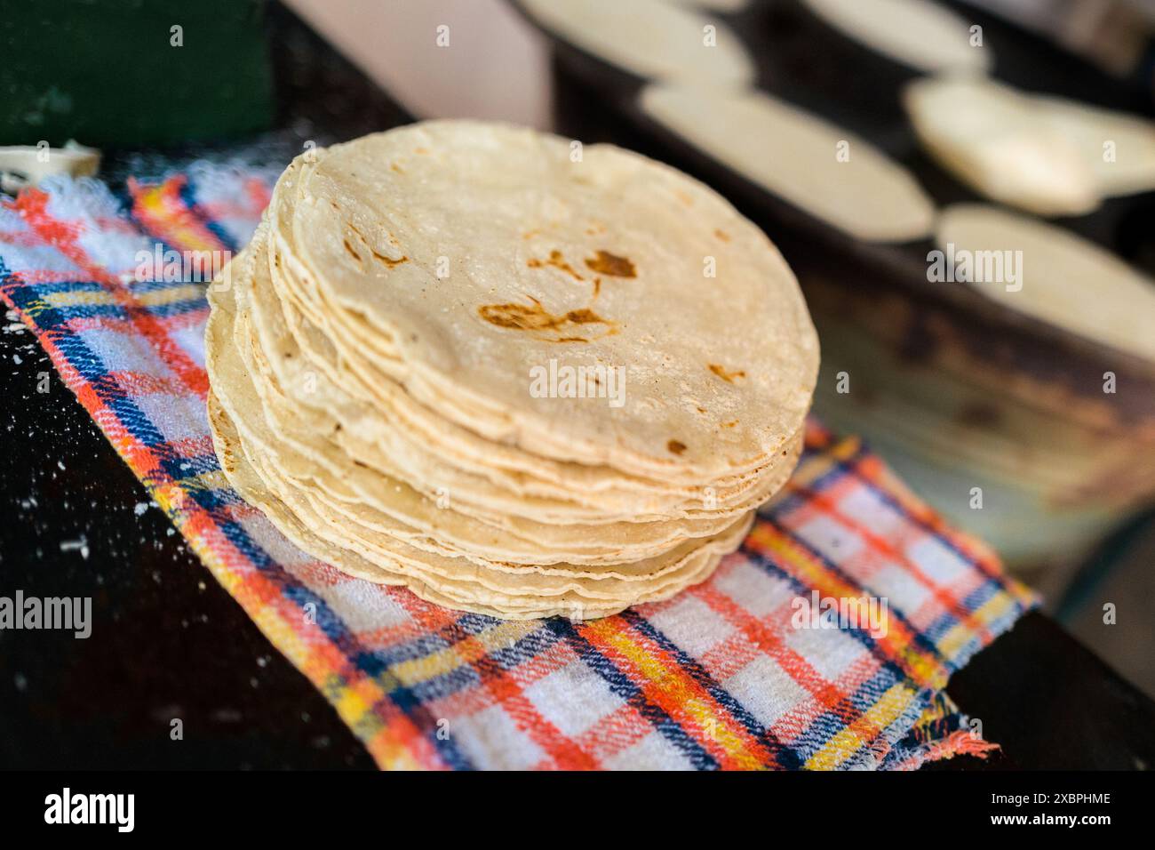Un tas de tortillas fraîchement préparées est vu placé sur un tissu dans un tortillería à Morelia, Michoacán, Mexique. Banque D'Images