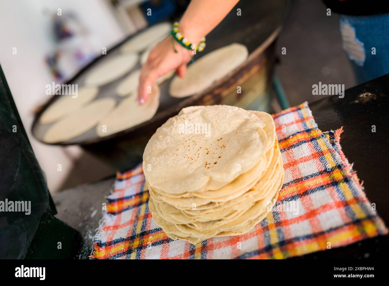 Un tas de tortillas fraîchement préparées est vu placé sur un tissu dans un tortillería à Morelia, Michoacán, Mexique. Banque D'Images