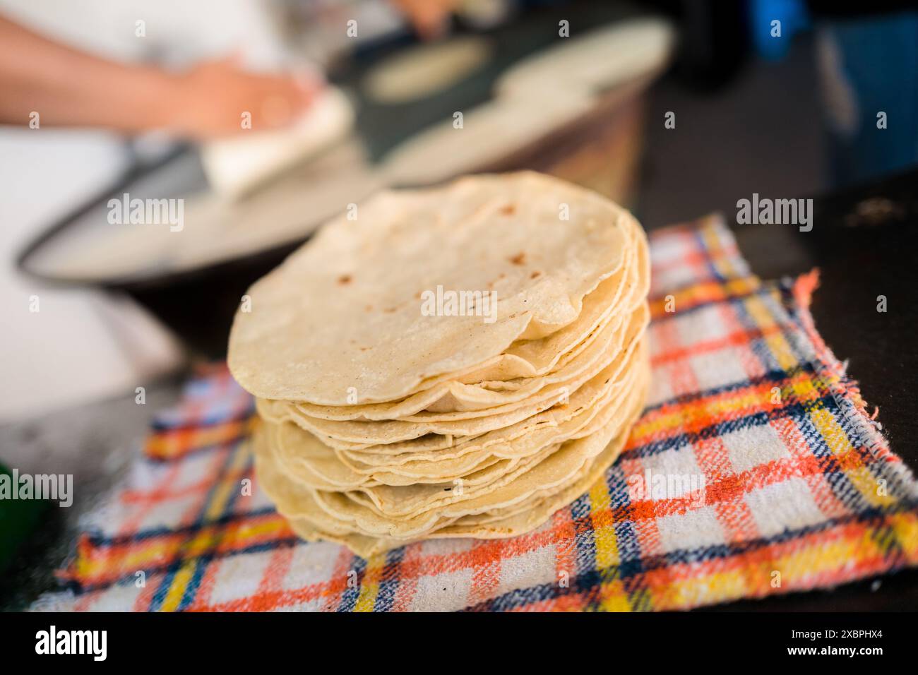 Un tas de tortillas fraîchement préparées est vu placé sur un tissu dans un tortillería à Morelia, Michoacán, Mexique. Banque D'Images