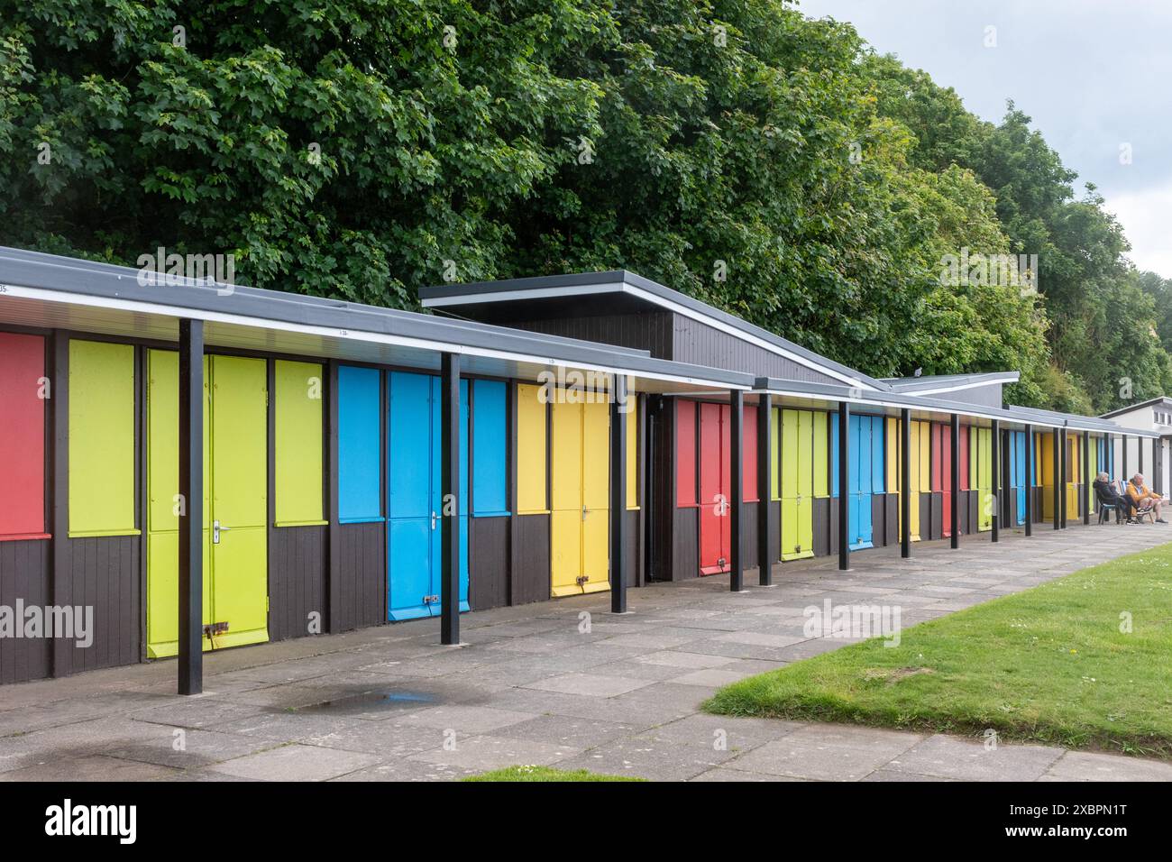 Filey, North Yorkshire, Angleterre, Royaume-Uni, vue le long de la promenade ou du front de mer à la station balnéaire avec des chalets de plage colorés sur la parade royale Banque D'Images