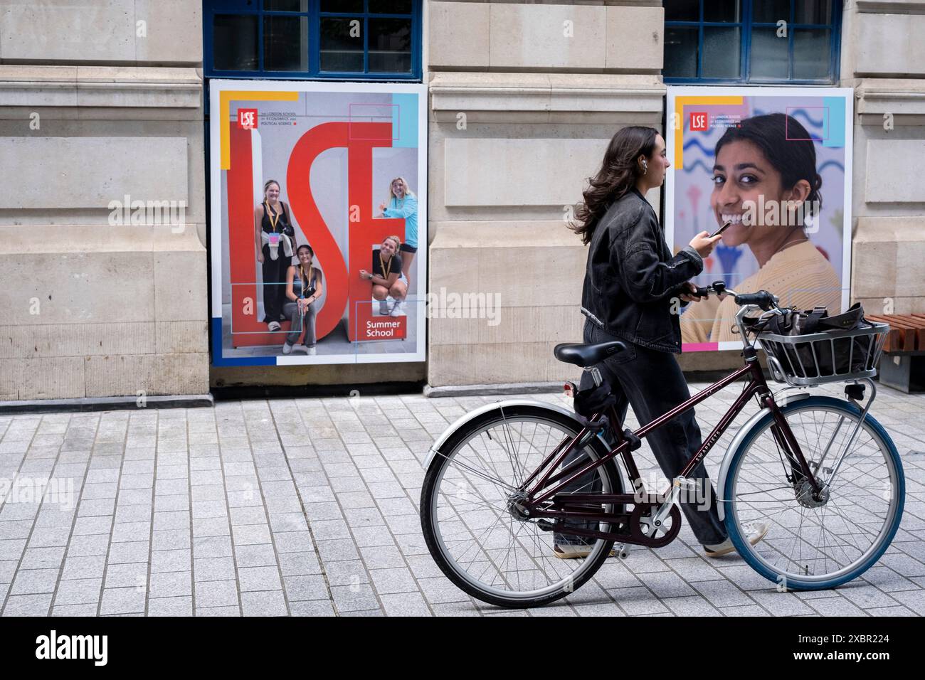 Étudiants autour du campus de la LSE London School of Economics passant une affiche LSE Summer School le 10 juin 2024 à Londres, Royaume-Uni. La London School of Economics and Political Science est une université de recherche publique située à Londres, en Angleterre, et un collège constitutif de l'Université fédérale de Londres. La LSE compte plus de 11 000 étudiants, dont environ 70% viennent de l'extérieur du Royaume-Uni. Banque D'Images