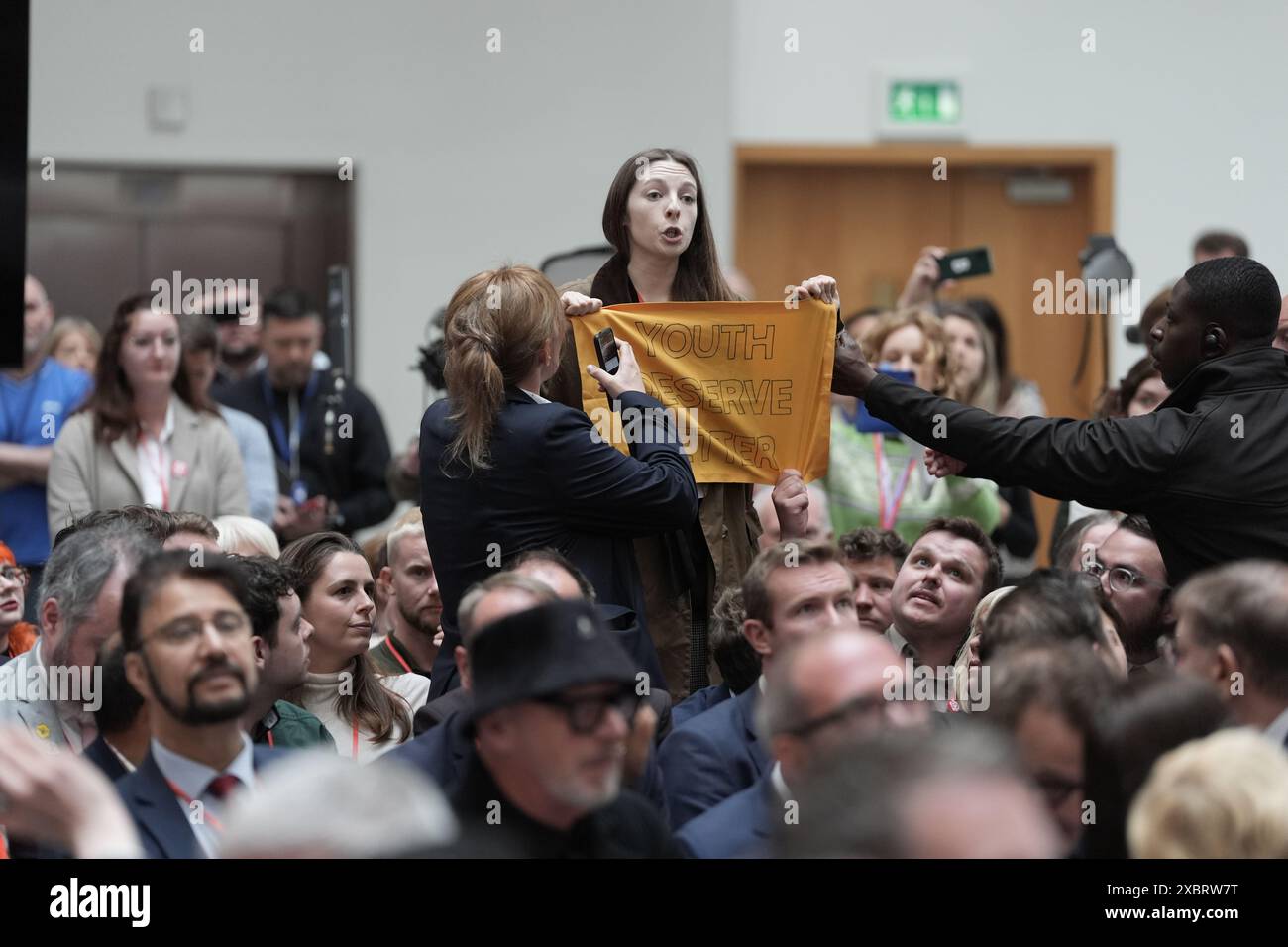 Un chahuteur qui est éjecté alors que le chef du Parti travailliste Sir Keir Starmer lance le manifeste de son parti au QG de la Co-op à Manchester. Date de la photo : jeudi 13 juin 2024. Banque D'Images