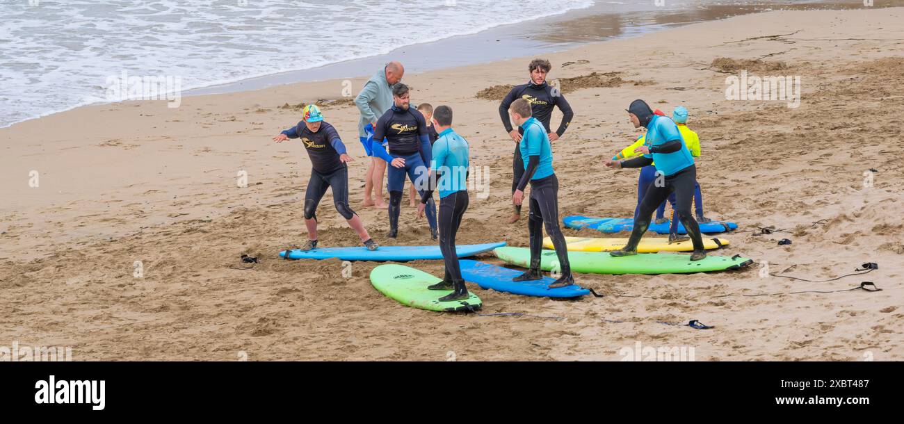 Des instructeurs de surf guident les enseignants du Surf Sanctuary enseignant un groupe d'apprenants novices de surf sur Fistral Beach à Newquay en Cornouailles au Royaume-Uni Banque D'Images