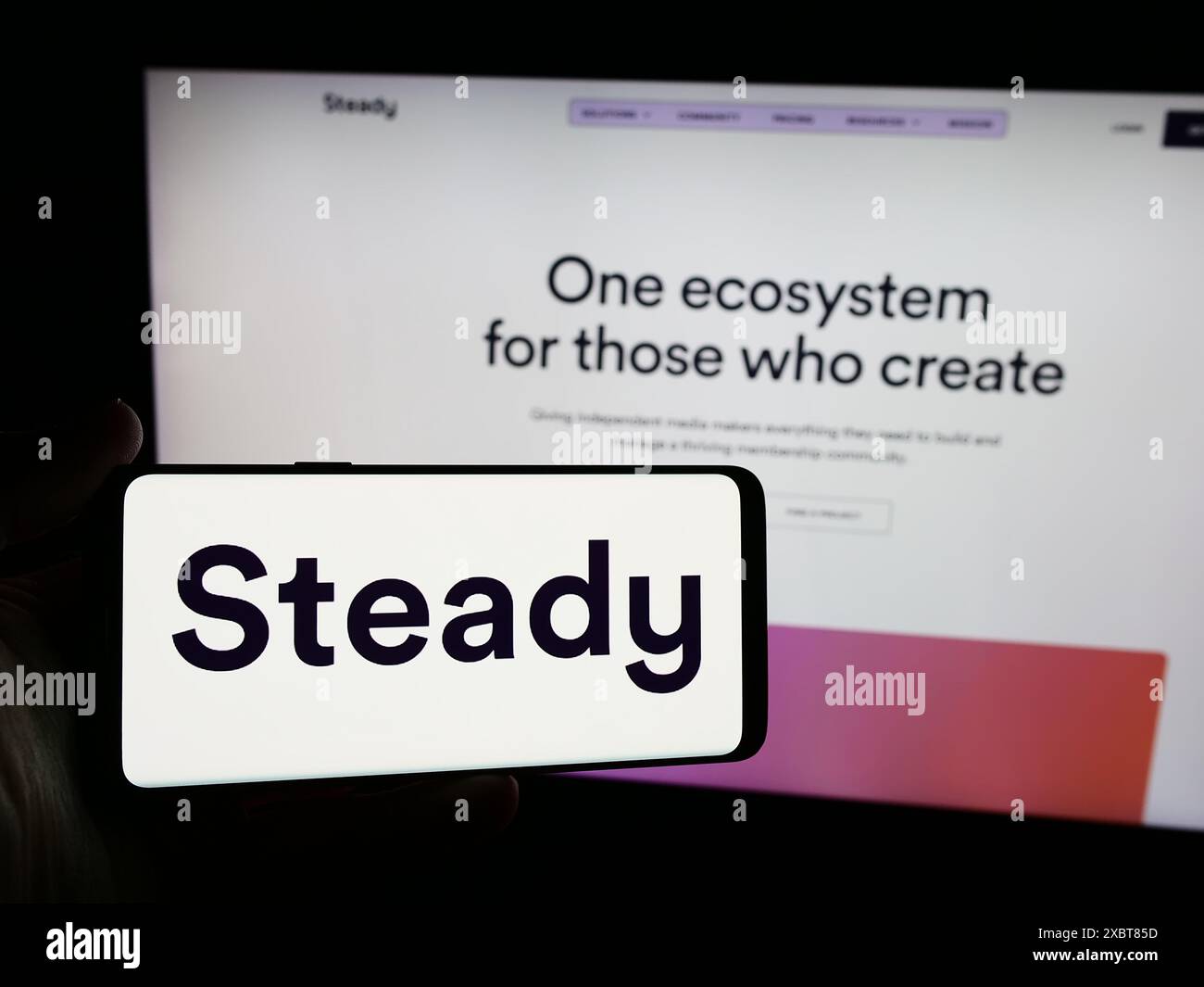 Personne tenant un smartphone avec le logo de la société allemande de crowdfunding Steady Media GmbH en face du site Web. Concentrez-vous sur l'affichage du téléphone. Banque D'Images