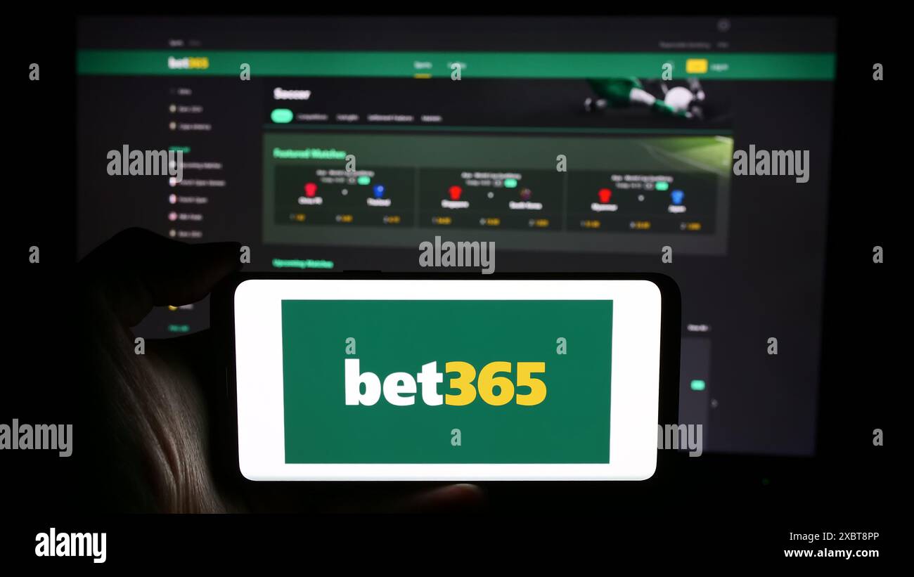 Personne tenant le téléphone portable avec le logo de la société britannique de Paris sportifs Bet365 en face de la page Web de l'entreprise. Concentrez-vous sur l'affichage du téléphone. Banque D'Images