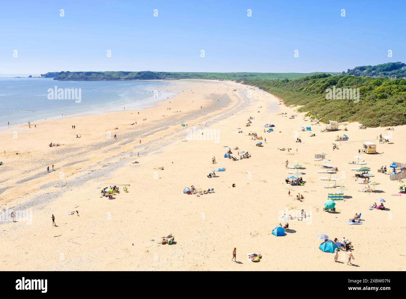 Plage de Tenby South vers Penally avec des personnes bronzant sur la longue plage de sable fin Tenby Pembrokeshire Carmarthan Bay West Wales UK GB Europe Banque D'Images