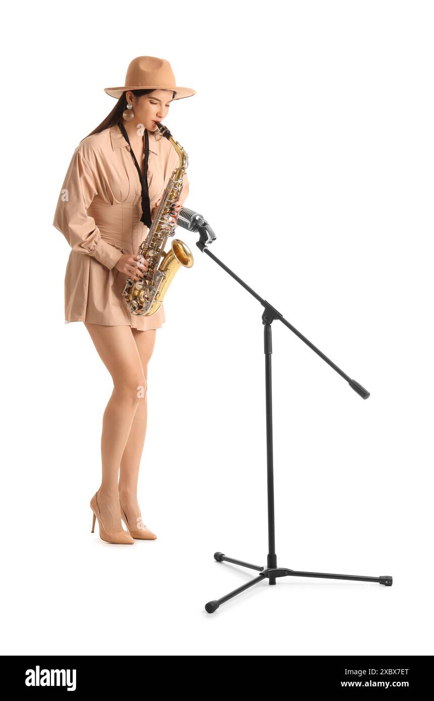 Belle femme avec microphone jouant du saxophone sur fond blanc Banque D'Images