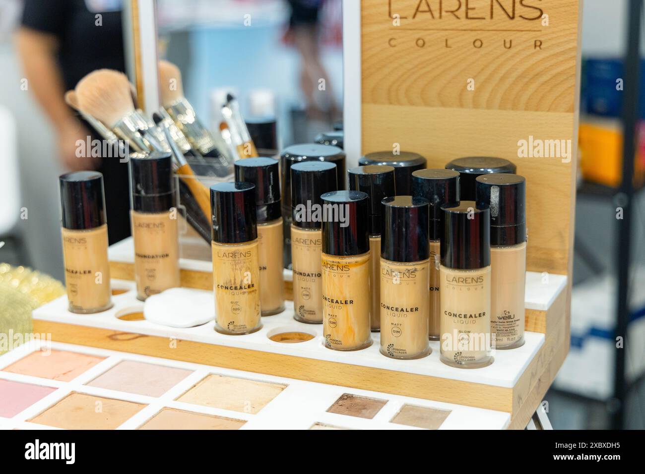 Osijek/ Croatie - 7 06 2024 : salon de la santé et de la beauté. exposition de bouteilles de correcteur au comptoir de maquillage. Les bouteilles sont disposées en rangée sur un s en bois Banque D'Images