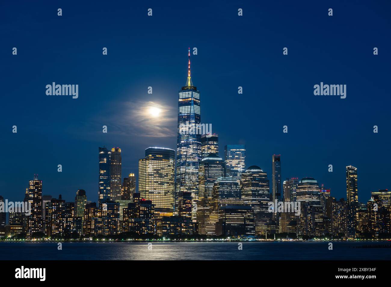 Horizon de Manhattan vu de Hoboken, New Jersey, au crépuscule, avec la lune derrière quelques nuages. Banque D'Images