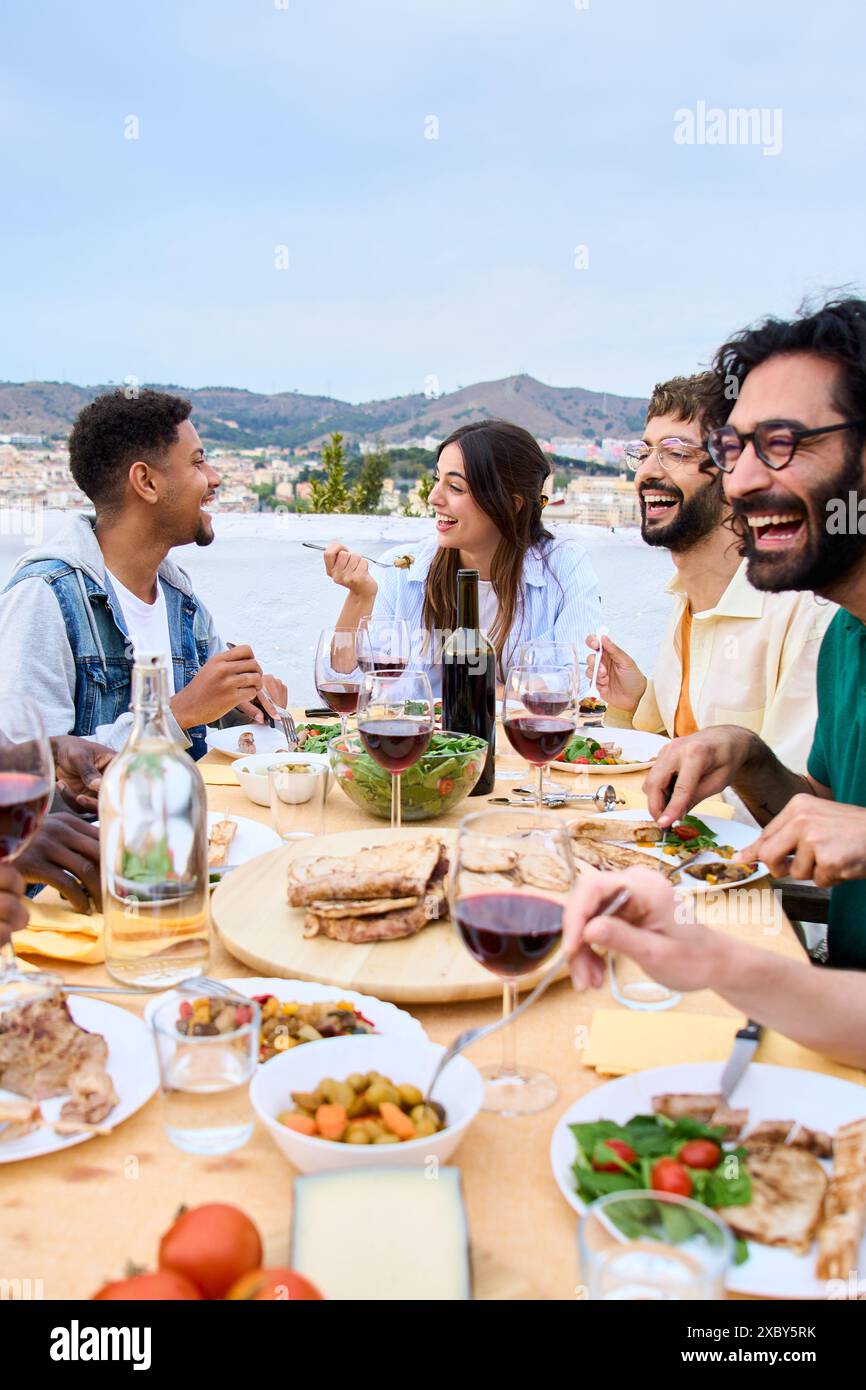 Personnes assises en train de boire un verre en terrasse en souriant et ...